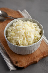 Homemade German Sauerkraut in a Bowl on a gray background, side view.