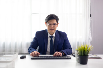 Businessman making video call conference. Asian business male wearing glasses looking at camera and...