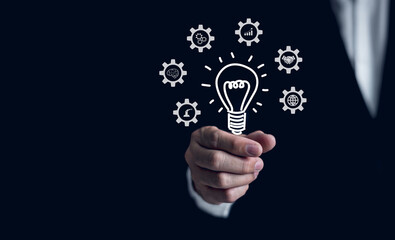 Businessman's hand holds a virtual light bulb icon. Creative concept. new innovations, Creativity, research and experimentation with inventions, technological progress Finance, and marketing.