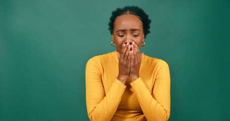 Young Black woman yawns and covers mouth, green background studio video