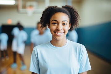Portrait of a young female basketball player posing in a indoor basketball gym