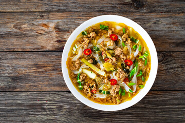Yunnan rice noodle soup on wooden table