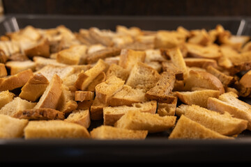Oven-toasted croutons cool on a metal baking sheet