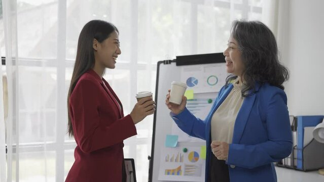 Older business woman and young Asian accountant talking about company finances and accounting business in the office Senior Asian businesswoman meeting and talking with colleagues