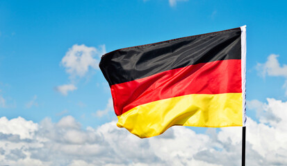 German flag waving against blue sky
