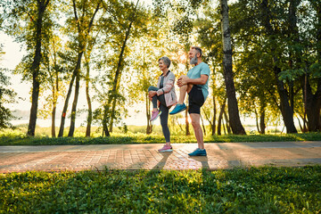 Healthy seniors working out outside. Side view of two dynamic family partners standing on pathway...