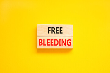 Free bleeding symbol. Concept words Free bleeding on beautiful wooden block. Beautiful yellow table...