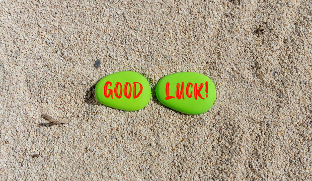 Good luck symbol. Concept words Good luck on beautiful green stone. Beautiful sea sand beach background. Business, motivational good luck concept. Copy space.