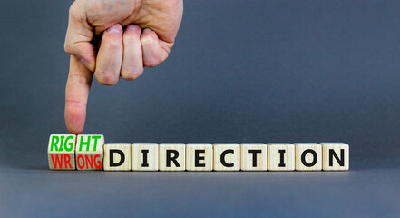 Right or wrong direction symbol. Concept words Right direction Wrong direction on wooden blocks. Beautiful grey background. Businessman hand. Business right or wrong direction concept. Copy space.