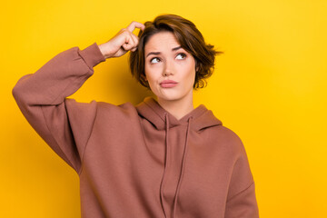Portrait of ponder pensive girl bob hair dressed brown sportswear scratches her head look empty...