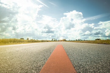 A two-lane rural highway with rice fields on both sides.