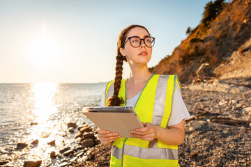 Inspection environmentalist. Portrait of young Caucasian woman wearing glasses using tablet. In...