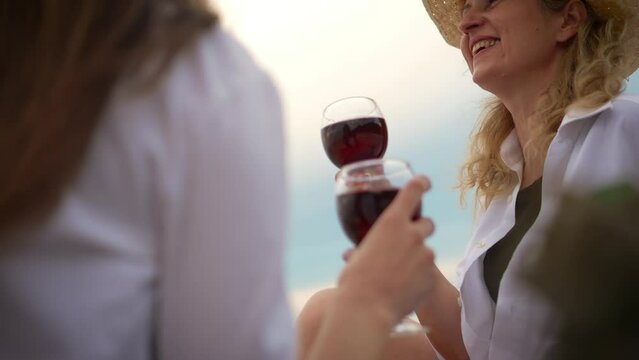 Loving lesbian pair with glasses of red wine, basking in vacation relaxation amidst blue sky backdrop. Lesbians bisexual transgender movements and love