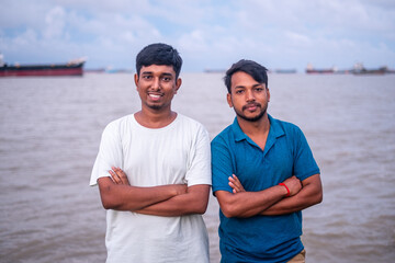 Portrait of south asian young boys standing in front of a river wearing casual t shirt 
