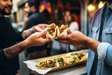 Deurstickers A chef gives a taco to a man at a street food market © pilipphoto
