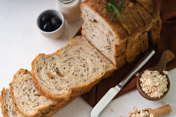 Fresh Sliced Homemade Wholegrain Wheat Bread whit olive oil on white rustic background. Artisan Sourdough