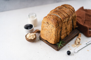Fresh Sliced Homemade Wholegrain Wheat Bread whit olive oil on white rustic background. Artisan Sourdough