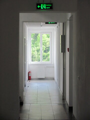 In the corridor at the factory, there are signs for the exit from the production premises