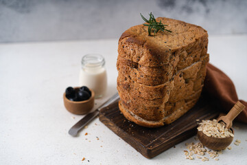Fresh Sliced Homemade Wholegrain Wheat Bread whit olive oil on white rustic background. Artisan Sourdough