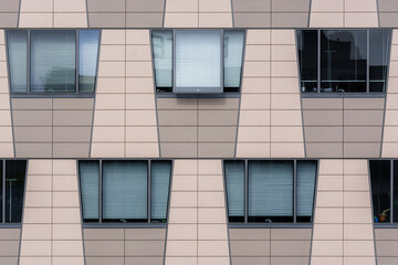Beige wall of a modern building with trapezoidal windows. From the Windows of the world series.