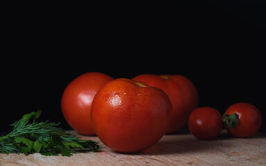 Red tomatoes on a dark background on the table