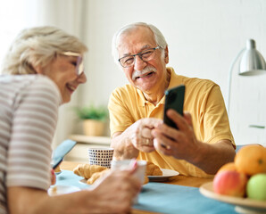 woman man senior couple home mobile phone phone retirement communication breakfast wife husband...