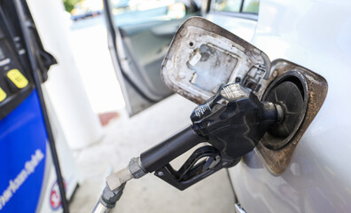 gas pump stands outside a hospital, representing rising fuel costs impacting healthcare budgets,...