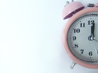 The old pink alarm clock showed one minute past twelve. isolated on white background close up view...