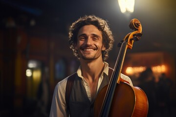 A man holding a cello and smiling at the camera. Perfect for musicians, music lovers, and classical music enthusiasts. - obrazy, fototapety, plakaty