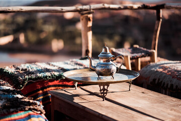 An Arabic teapot on the table at sunset 