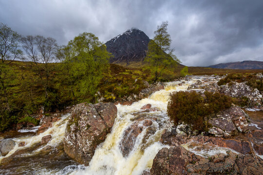 Waterfall on River Coupal and mountain range Buachaille Etive Mor in the background at Glen Coe in Scotland, United Kingdom