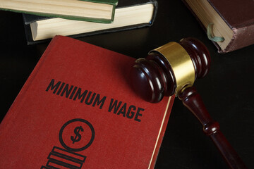 Minimum wage increase and minimum wage law are shown using the text on the book and photo of gavel