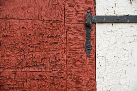 Old wrought iron hinge on a weathered door and frame; Sisimiut, Greenland