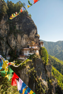 Prayer flags span the chasm before the Tiger's Nest Monastery in Bhutan; Paro, Bhutan