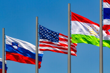 Flags of the United States, the Republic of Slovenia and Republic of Tajikistan waving in the wind