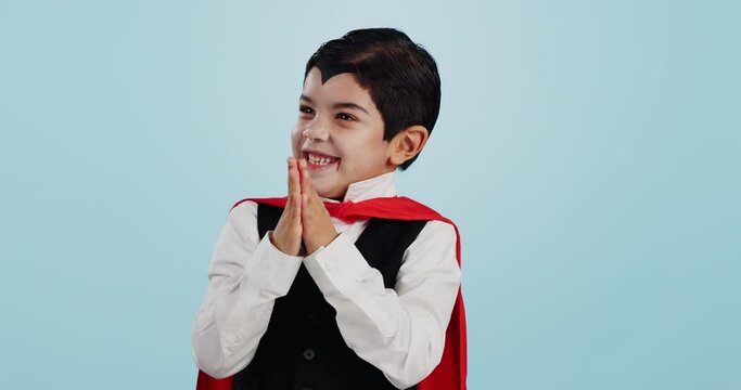 Choice, halloween and excited child in costume ready for event, hungry and isolated in a studio blue background. Option, vampire and funny young kid with comedy, joy and happiness for holiday