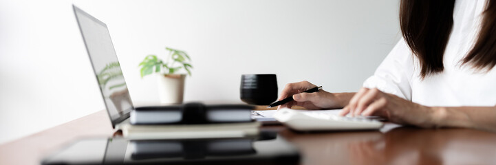 Writer woman calculate and check financial business document with calculator while working in cafe