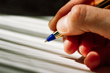 A ballpoint pen in a woman's hand. A man writes in a blank notebook. Life from a clean slate,...