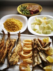 Typical Spanish food, migas, garnished with peppers, melon, fried fish, chorizos and bacon