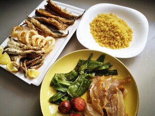 Typical Spanish food, migas, garnished with peppers, melon, fried fish, chorizos and bacon