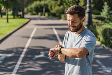 Uses a fitness tracker and a mobile app for running. The instructor is a male sports runner interval training. Mental and psychological health during fitness exercises. - obrazy, fototapety, plakaty