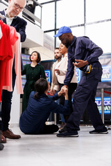 Black Friday shopper injuries. African American guy security guard wearing uniform keeping clothing...