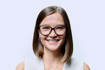 Obraz premium Headshot portrait of young beautiful woman in glasses, on white studio background