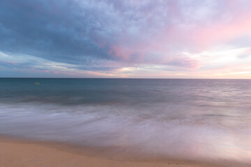 Cloudscape and seascape at ocean sunset with sandy beach in Portugal