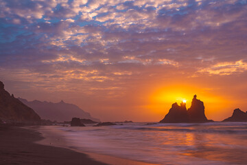 fiery summer sunset behind the typical rocks of benijio beach in the north east of tenerife island