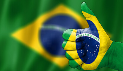 thumbs up in approval with the brazilian flag painted,
