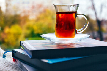 A cup of tea with books on a windowsill