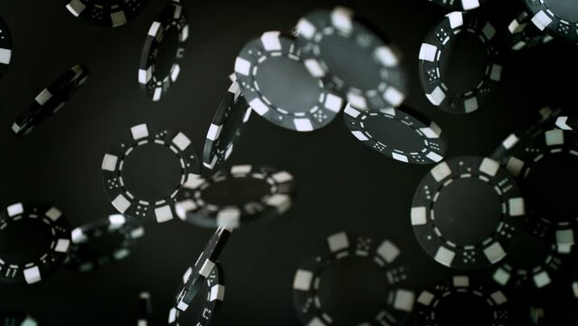 Super Slow Motion Shot of Casino Chips Explosion Towards Camera on Black Background at 1000fps.
