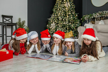 Fototapeta premium Merry Christmas and Happy Holidays. Group children reading Christmas tales. Concept holiday