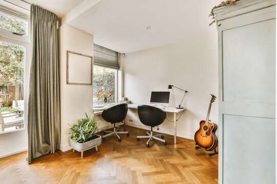 Home office with desk and guitar by window